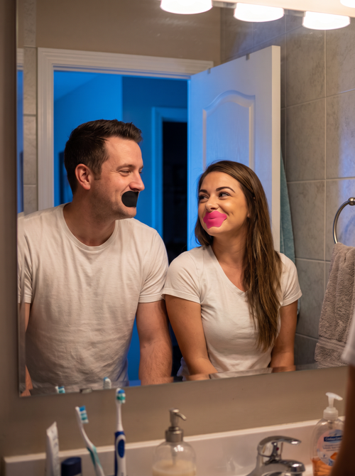 Couple applying their strips together at the mirror